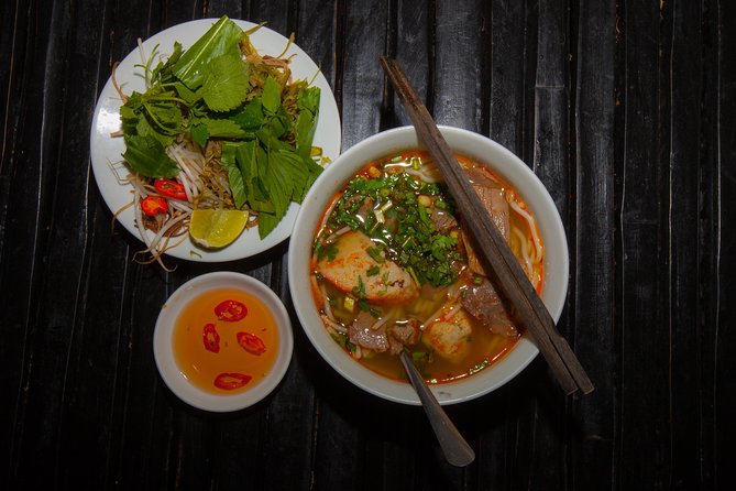 Saigon Night Street Food and City Tour on Scooter - Noodle soup in a local setting